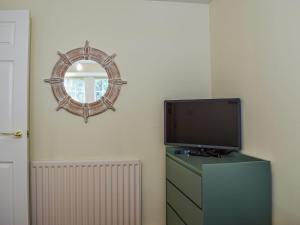 a tv sitting on a dresser next to a mirror at Ardvar in Crail