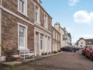 a street of houses with a bench on the sidewalk at Ardvar in Crail