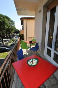 una mesa roja con un plato de comida en el balcón en B&B Gate 52, en Pisa