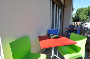 a red and green table and chairs on a balcony at B&B Gate 52 in Pisa