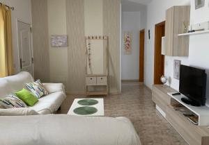 a living room with a white couch and a television at Apartamento MAFASCA in Las Playas