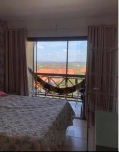 1 dormitorio con 1 cama y balcón con hamaca en Flat Monte Castelo - Gravatá, en Bezerros