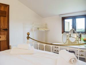 ein weißes Schlafzimmer mit einem Bett und einem Spiegel in der Unterkunft The Summerhouse - Uk34933 in Baschurch