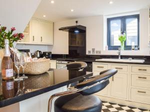 a kitchen with a counter with a bar stool at The Potting Shed in Preston Wynne