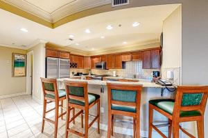 a kitchen with a center island with bar stools at Emerald Grande 324 in Destin