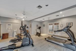 a gym with treadmills and ellipticals in a room at A Foot in the Shore in Naples