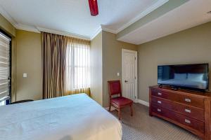 德斯坦的住宿－Emerald Grande 324，一间卧室配有一张床和一台平面电视