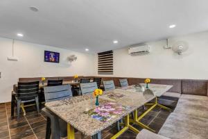 uma sala de jantar com mesas e cadeiras e um sofá em Bluerock Resort em Tirupati