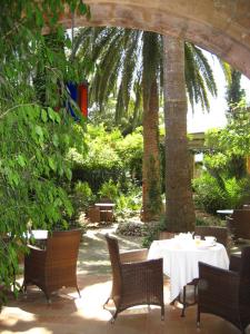 un patio con mesa, sillas y palmeras en Finca Raims, en Algaida