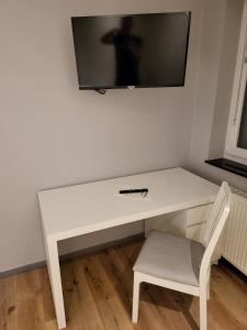 a white desk with a television on a wall at "Anderer´s" Gasthaus & Hotel Hohne in Hohne