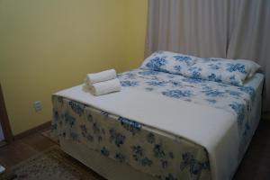 a bed with blue and white sheets and pillows at Ipê Rosa Hotel in Bauru