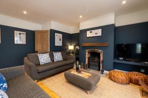 a living room with a couch and a fireplace at Pinewood - Aldeburgh Coastal Cottages in Aldeburgh