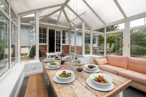 a conservatory with a table with bowls of fruit on it at Pinewood - Aldeburgh Coastal Cottages in Aldeburgh