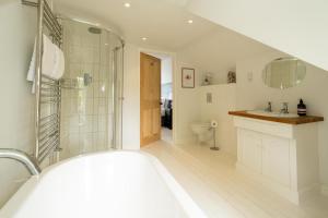 a bathroom with a tub and a sink and a toilet at Pinewood - Aldeburgh Coastal Cottages in Aldeburgh +37 photos