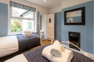 a bedroom with a bed and a fireplace at Pinewood - Aldeburgh Coastal Cottages in Aldeburgh