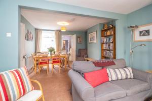 a living room with a couch and a dining room at 40 Buller Road - Aldeburgh Coastal Cottages in Leiston