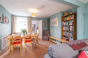 a living room with a table and chairs and a book shelf at 40 Buller Road - Aldeburgh Coastal Cottages in Leiston