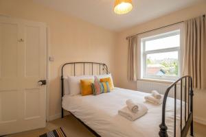 a bedroom with a bed with towels on it at 40 Buller Road - Aldeburgh Coastal Cottages in Leiston