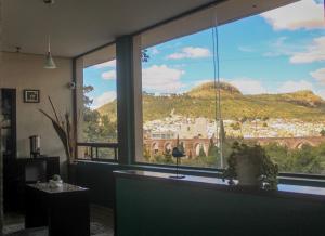 a room with a large window with a mountain view at Hotel Alika in Zacatecas