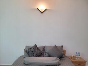 a couch in a living room with a light on the wall at Yana House Phnom Penh in Phnom Penh