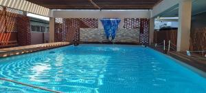 una piscina con una fuente en una habitación de hotel en Waterland Suites en Paramaribo