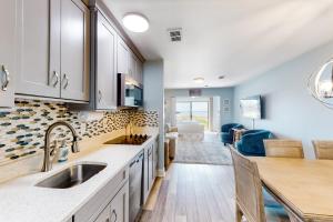 a kitchen with a sink and a living room at Sunset Harbor Palms 2-108 in Navarre