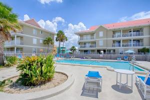 a pool with a table and chairs in front of a building at Sunset Harbor Palms 2-108 in Navarre