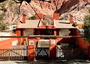 a building with a gate in front of a mountain at Chilcagua in Purmamarca
