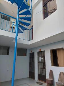 a spiral staircase in a building with a blue pole at Benkawasi Experience Huaraz in Huaraz