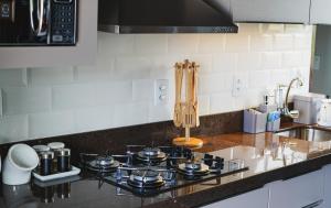 a kitchen counter with a stove and a sink at Casa Master frente da praia in Guarda do Embaú +34 photos