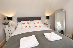 a bedroom with a large white bed with two pillows at Moorland View Lodge in Baslow