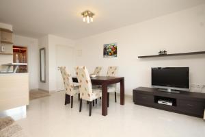 a dining room with a table and chairs and a television at Apartments with a parking space Icici, Opatija - 7785 in Ičići