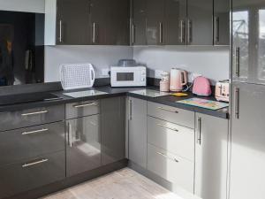 a kitchen with black cabinets and a white microwave at Joes Place in Mablethorpe