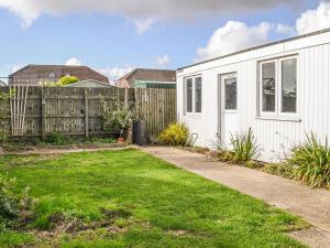 a backyard with a white house and a fence at Joes Place in Mablethorpe