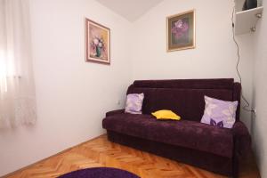 a living room with a purple couch with two pillows at Apartments with a parking space Ravni, Labin - 7674 in Ravni
