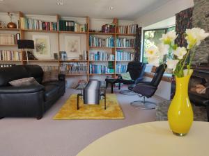 uma sala de estar com um vaso de flores sobre uma mesa em Golden Caves - Bed & Breakfast em Takaka