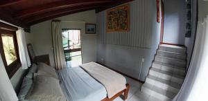 a small bedroom with a bed and a window at Casa Master frente da praia in Guarda do Embaú