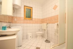 a bathroom with a toilet and a sink at Apartments with a parking space Sveti Jakov, Losinj - 8011 in Nerezine