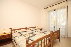 a bedroom with a large bed and a window at Apartments by the sea Cove Merascica, Cres - 8071 in Štivan