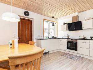 een keuken en eetkamer met een houten tafel bij Holiday home Rudkøbing XIX in Spodsbjerg