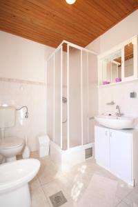 ein weißes Bad mit einem WC und einem Waschbecken in der Unterkunft Family friendly seaside apartments Susak, Losinj - 8050 in Susak