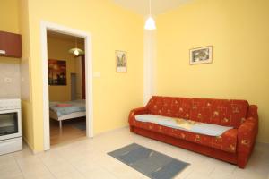 uma sala de estar com um sofá vermelho e uma cozinha em Apartments with a parking space Opatija - 7844 em Opatija