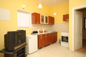 uma cozinha com armários castanhos e uma televisão em Apartments with a parking space Opatija - 7844 em Opatija