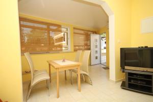 a dining room with a table and chairs and a television at Apartments with a parking space Opatija - 7844 in Opatija