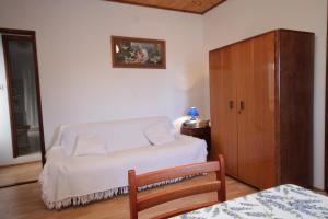 a bedroom with a white bed and a wooden cabinet at Apartments with a parking space Veli Losinj, Losinj - 8060 in Veli Lošinj