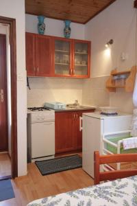 a kitchen with wooden cabinets and a white stove top oven at Apartments with a parking space Veli Losinj, Losinj - 8060 in Veli Lošinj