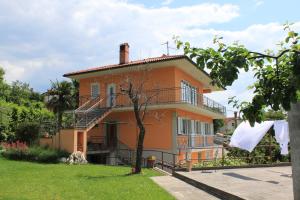 an orange house with a balcony and a yard at Apartments with a parking space Opatija - Pobri, Opatija - 7918 in Volosko
