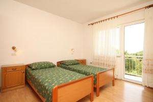 a bedroom with a bed and a large window at Apartments with a parking space Opatija - Pobri, Opatija - 7918 in Volosko