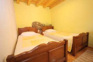 2 Betten in einem Zimmer mit gelben Wänden in der Unterkunft Holiday house with WiFi Mali Losinj (Losinj) - 8014 in Mali Lošinj