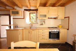 a kitchen with wooden cabinets and a stove at Holiday house with WiFi Mali Losinj (Losinj) - 8014 in Mali Lošinj
